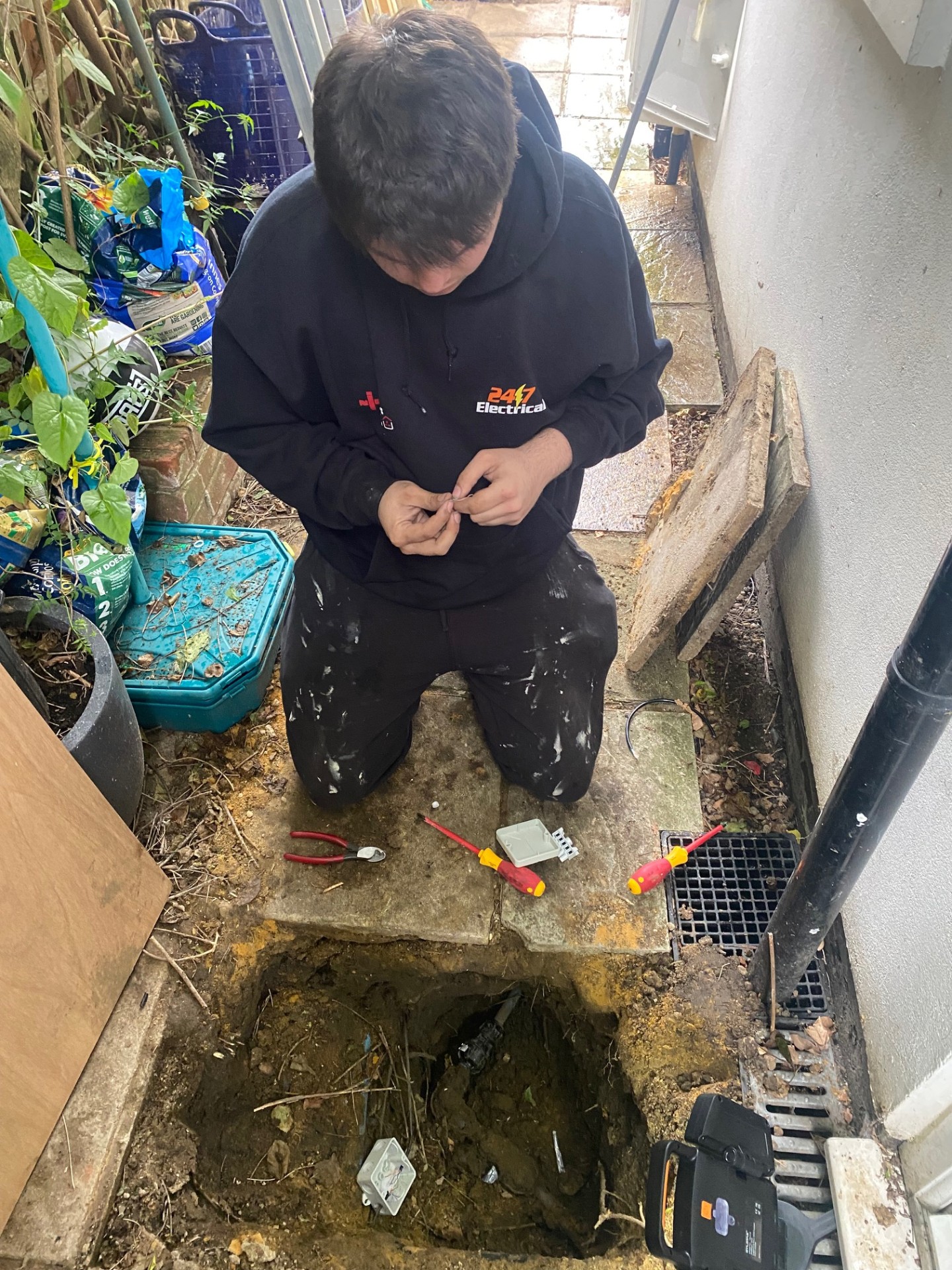 Electrician performing groundwork for outdoor installation