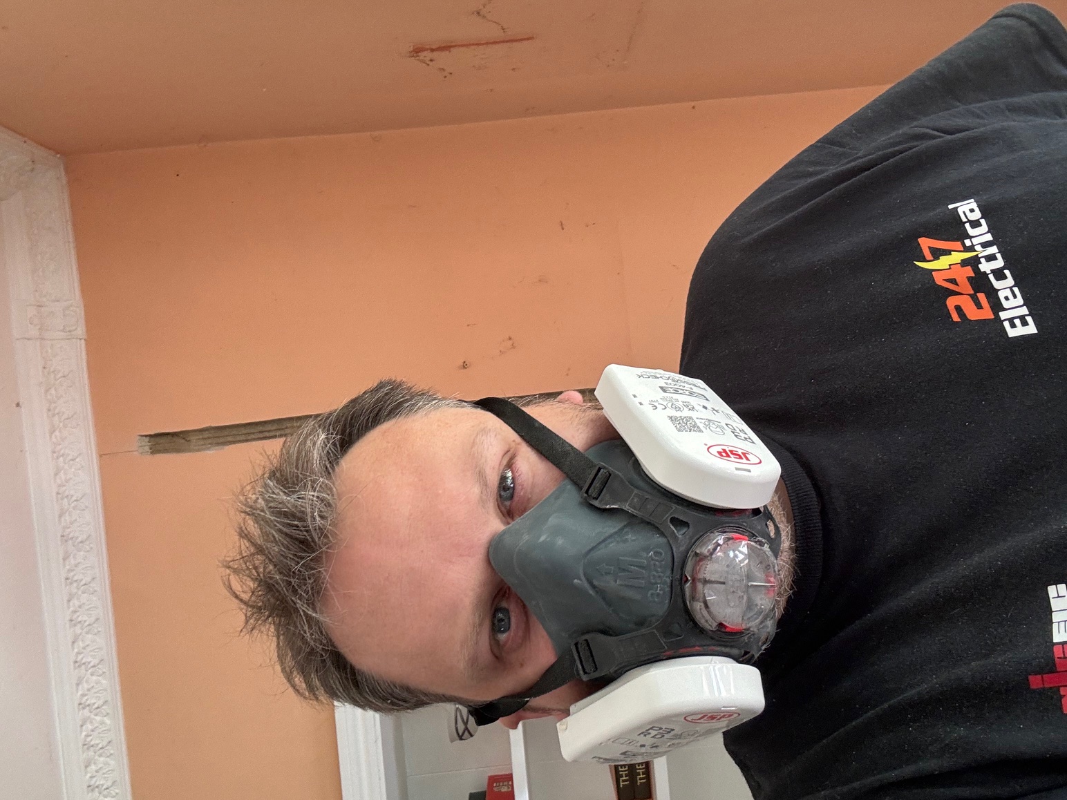 Engineer with respirator during dust-generating electrical work