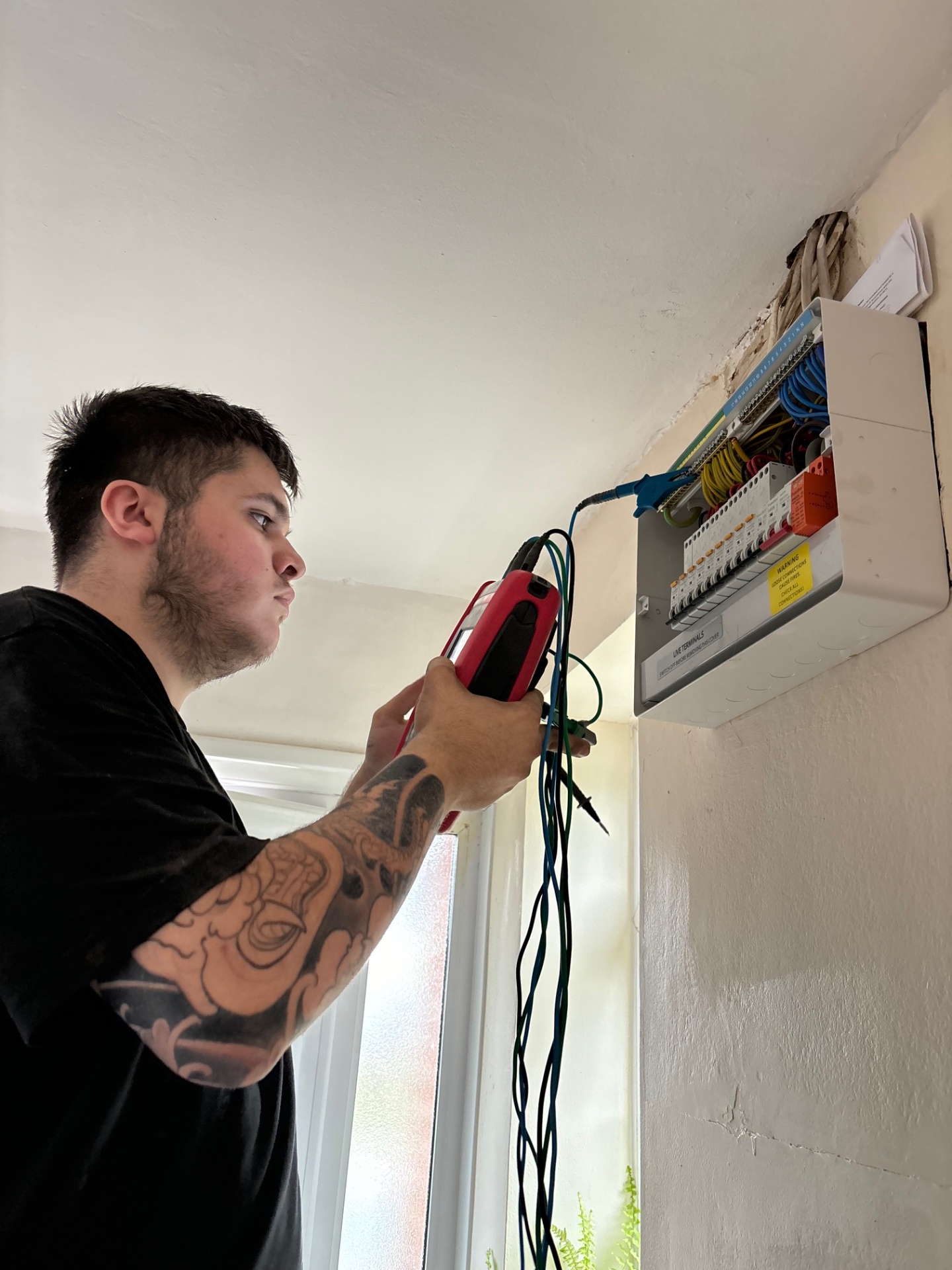 Electrician performing EICR electrical testing on a consumer unit in London